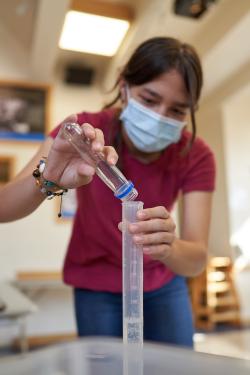 learner measuring water using graduated cylinder