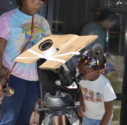 Pensacola Mess Hall in Florida event with a child looking through telescope to observe the Moon