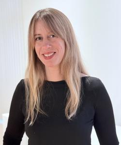 Headshot for Meghan Federer, online workshop presenter, individual from waist up wearing a long sleeve black top. They are smiling and have long straight blonde hair.