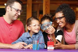 Parents and two children using Exploring Fabrication - Electroplating (NanoDays 2014)