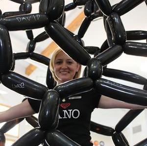 Person inside of a giant carbon nanotube model made of balloons