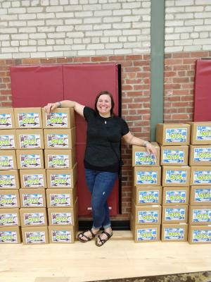 Maine discovery kits stacked with staff person standing between boxes