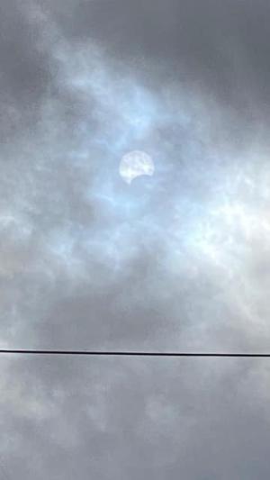 The Sun peeks through the clouds during a 2023 Annular Solar Eclipse Event