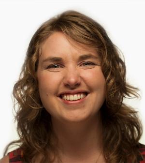 Katie Wolfson Headshot - woman with brownish shoulder-length hair smiles in photo from shoulders up
