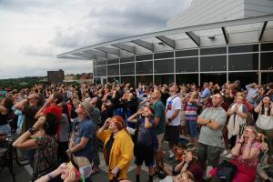 Crowd is Outside Looking to the Sky Awaiting to See a Partial Solar Eclipse