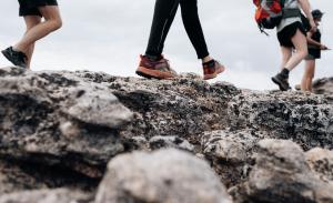 People wearing hiking boots walking on a rock. Photo by Shean Brookes on Unsplash