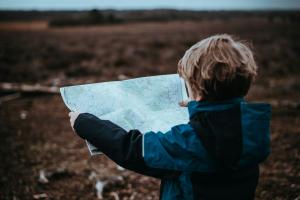 Navigating uncertainy - Child examining a map.