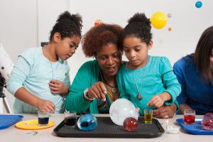 Mother and daughters using the Ice Orbs activity from the Explore Science: Earth & Space toolkit