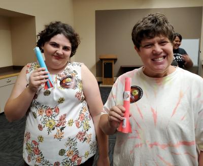 Two adults showing off their stomp rockets