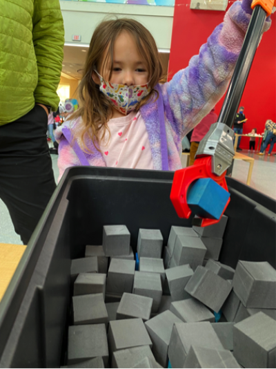 Girl using Moon Adventure Game activity at  Webb Space Telescope Event ​​​​​​​photo courtesy of Marbles Kids Museum