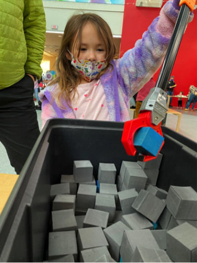 Girl using Moon Adventure Game activity at Webb Space Telescope Event photo courtesy of Marbles Kids Museum