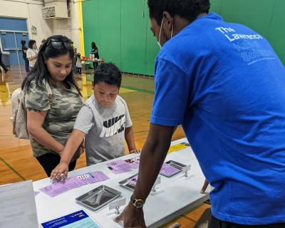 Visitors engage with a Lawrence staff member about vaccine information.