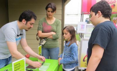 Children and adults using NanodDays Hands-on Thin Film activity from a past NanoDays event at Highland Road Park Observatory in Baton Rouge, Louisiana