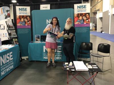 NISE Network staff members at ASTC conference booth in 2023 in Charlotte North Carolina