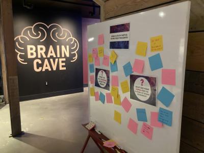 Allen Institute BrainFest at Pacific Science Center with a sticky wall of ideas about neuroscience and a Brain Cave sign