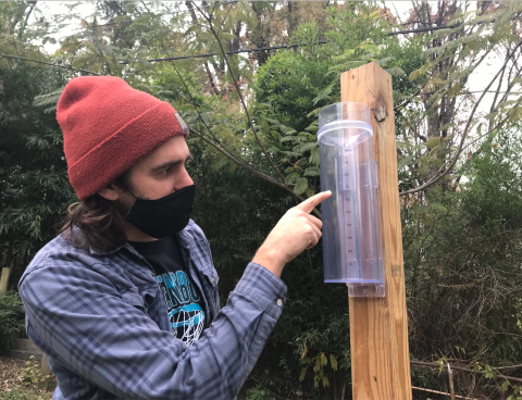 Citizen scientist taking a precipitation measurement on a CoCoRaHS rain gauge