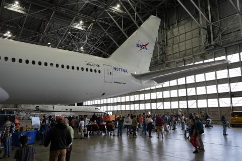 Boeing 777 Aircraft with a Large Crowd Around It with Activities Setup on Tables