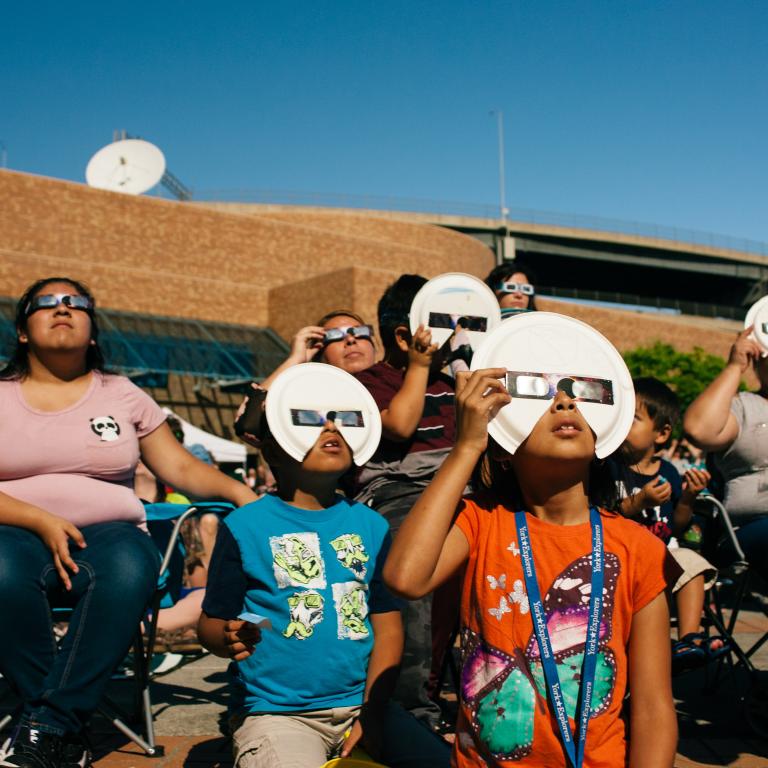 Family watching the solar eclipse safely