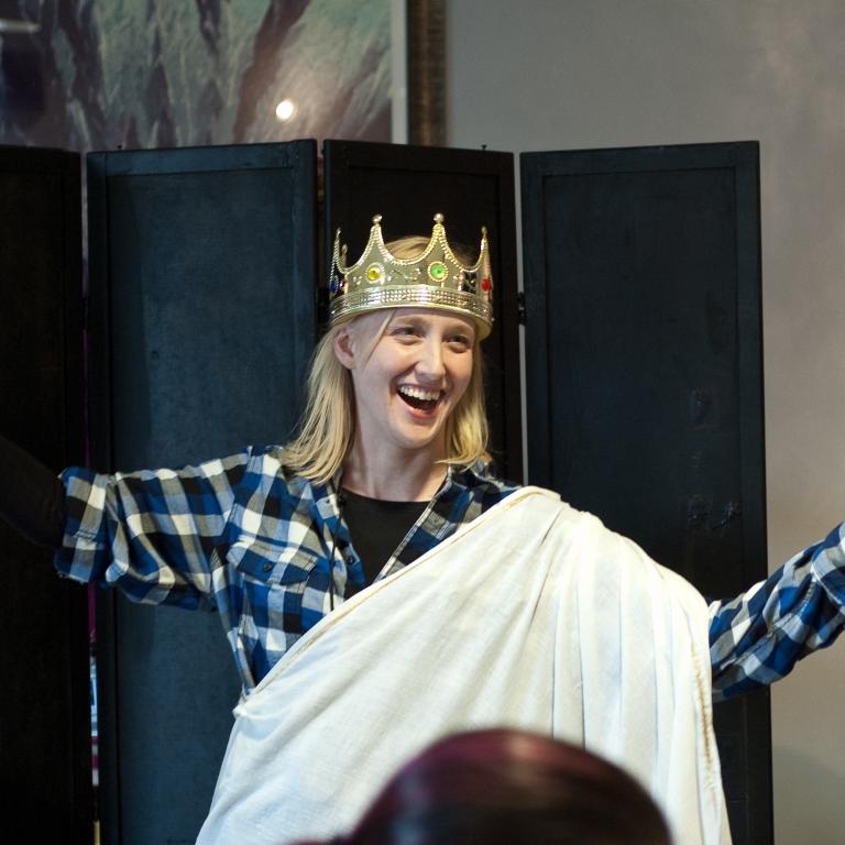 Woman dressed for theater play in crown and robe