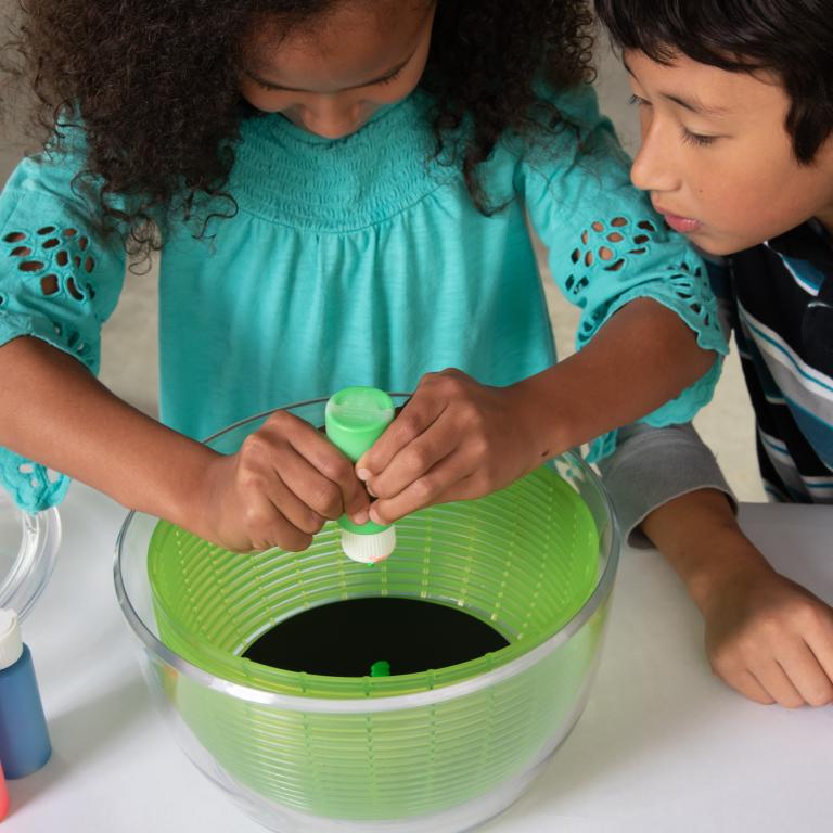 Girl using paint in nebula spin art activity