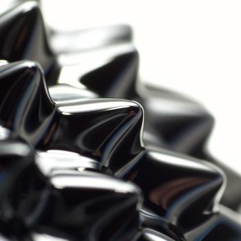 The surface of ferrofluid which is black, spikey (due to a magnetic field) and semi-glossy.