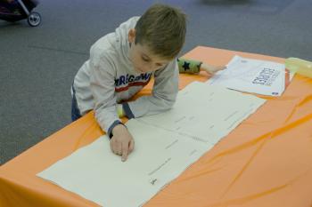 Child using the Braille book, called "Getting a Feel for Eclipses," features graphics that teach users about the interaction and alignment of the sun with the moon and Earth