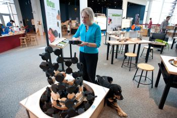Nano exhibition blind accessibilty expert with service dog feeling tactile aspects of Build a Giant Carbon Nanotube exhibit