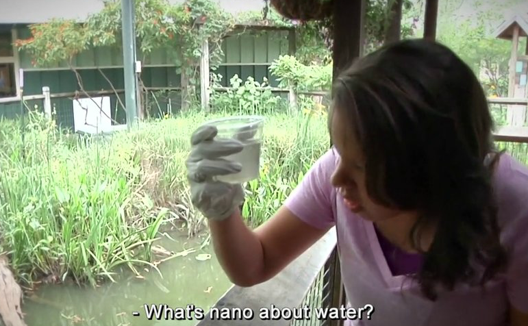 Person looking closely at a cup filled with dirty water