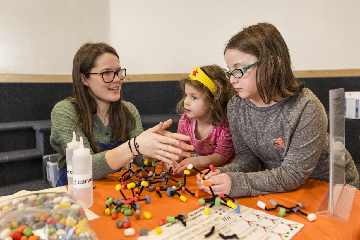 Two girls and an educator building models of molecules