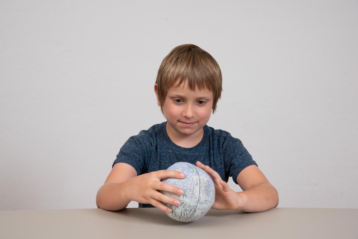 Learner looking at plushie model of the Moon