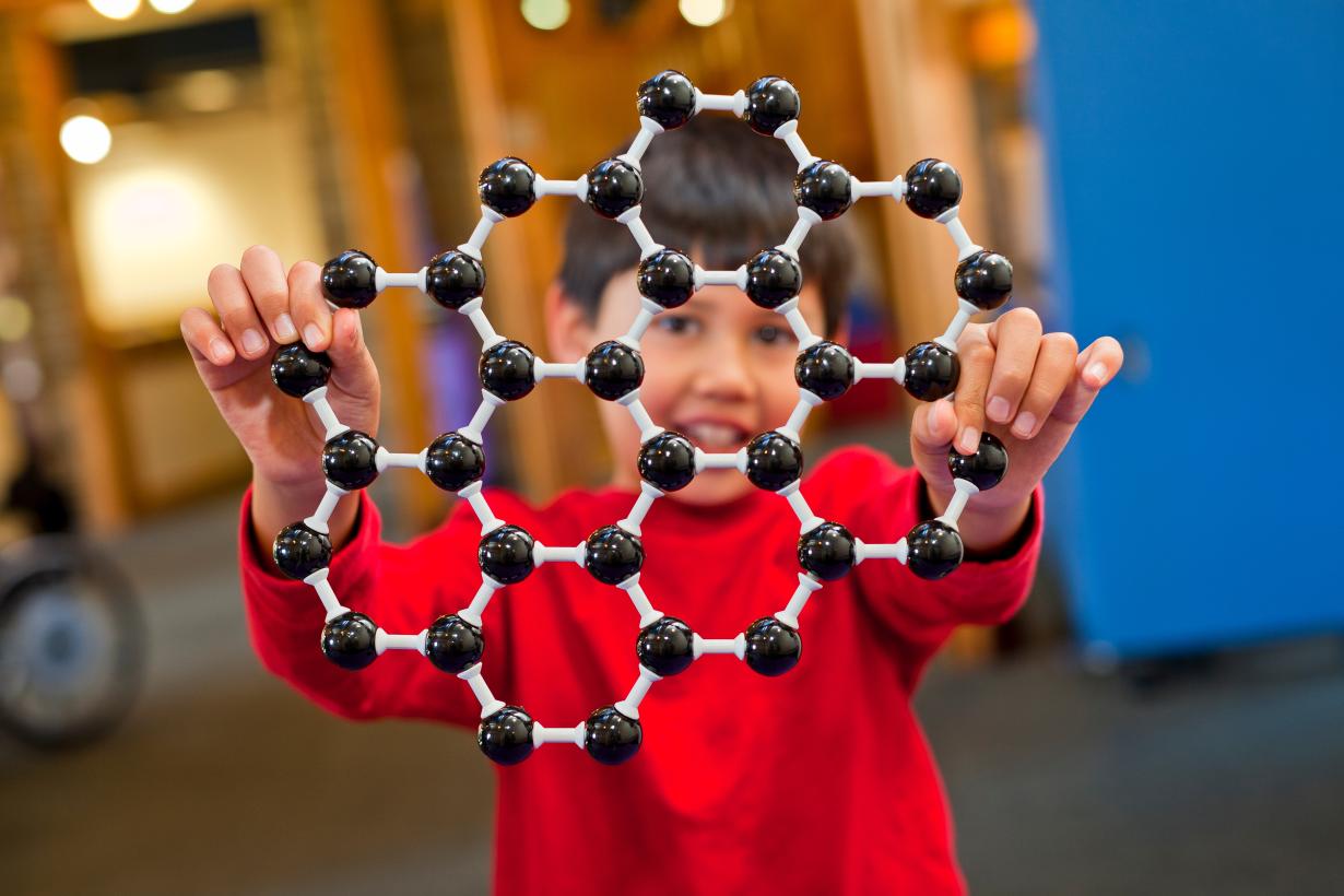 learner holding a molecular model