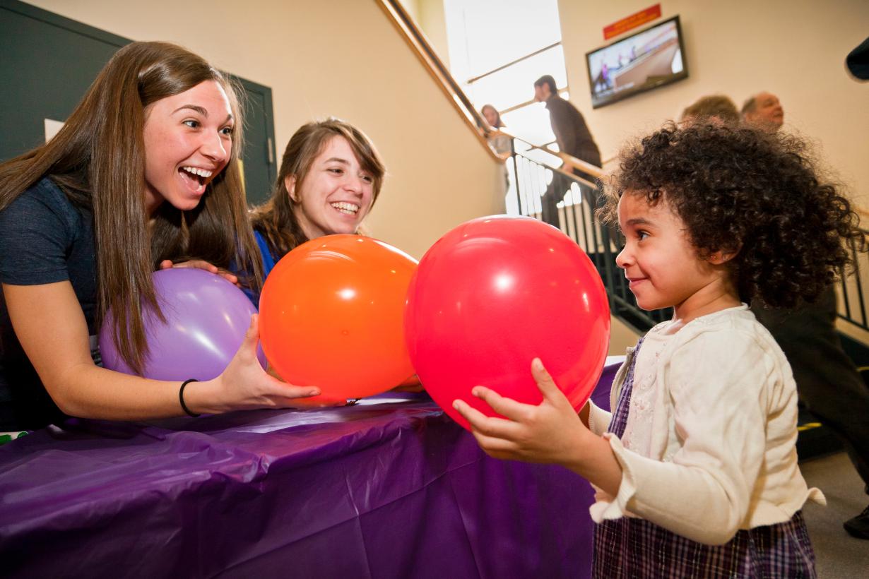Learner smells balloons with educators