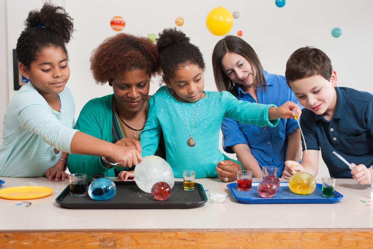 Children and adult investigating globes of ice in  Icy Orbs activity