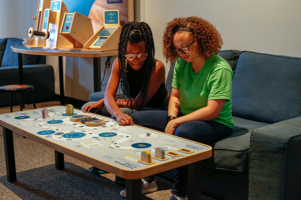 Girls playing space game in Sun Earth Universe exhibition