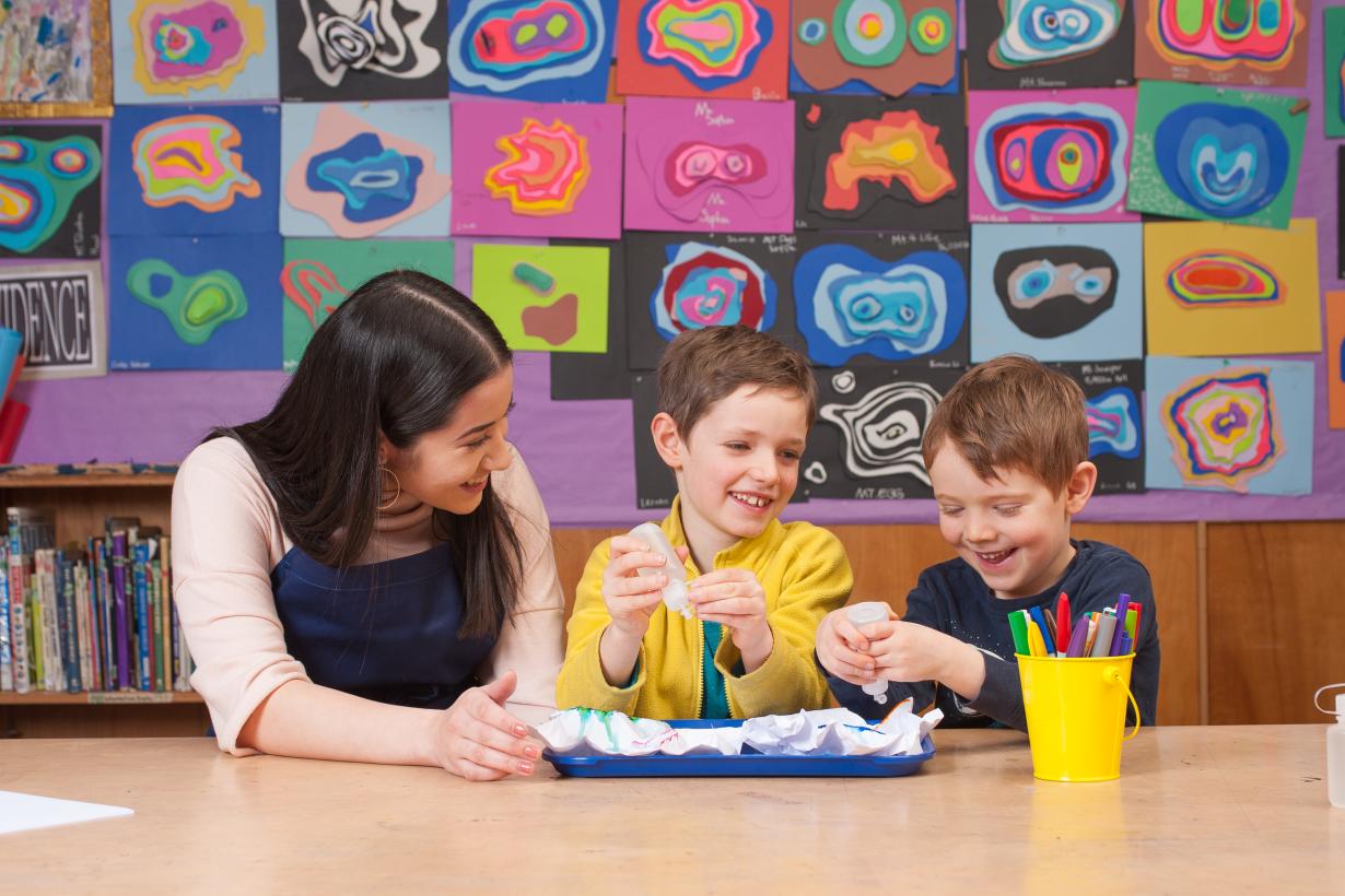 Caregiver and two children using the paper mountains activity 