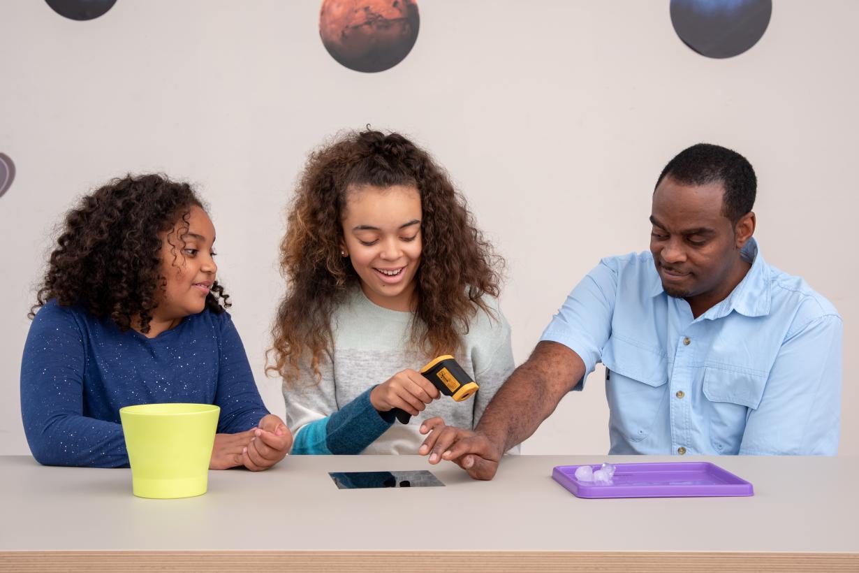 Family using thermometer to take temperature of their arm for the Heat Map activity