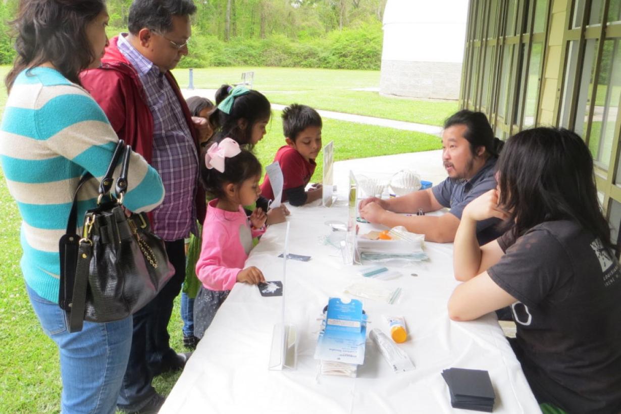 Children and adults using NanodDays Hands-on Sunblock activity from a past NanoDays event at Highland Road Park Observatory in Baton Rouge, Louisiana