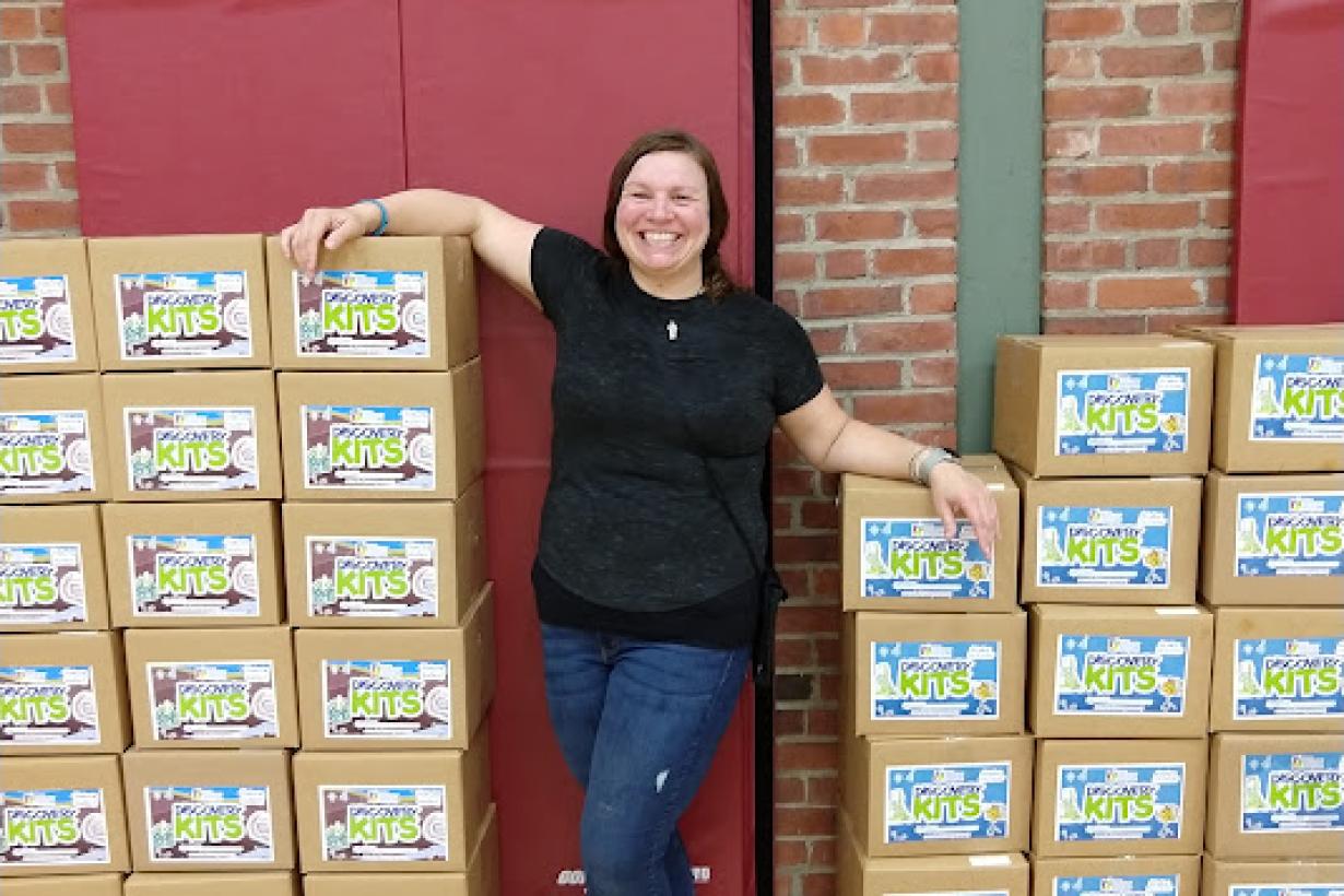 Maine discovery kits stacked with staff person standing between boxes