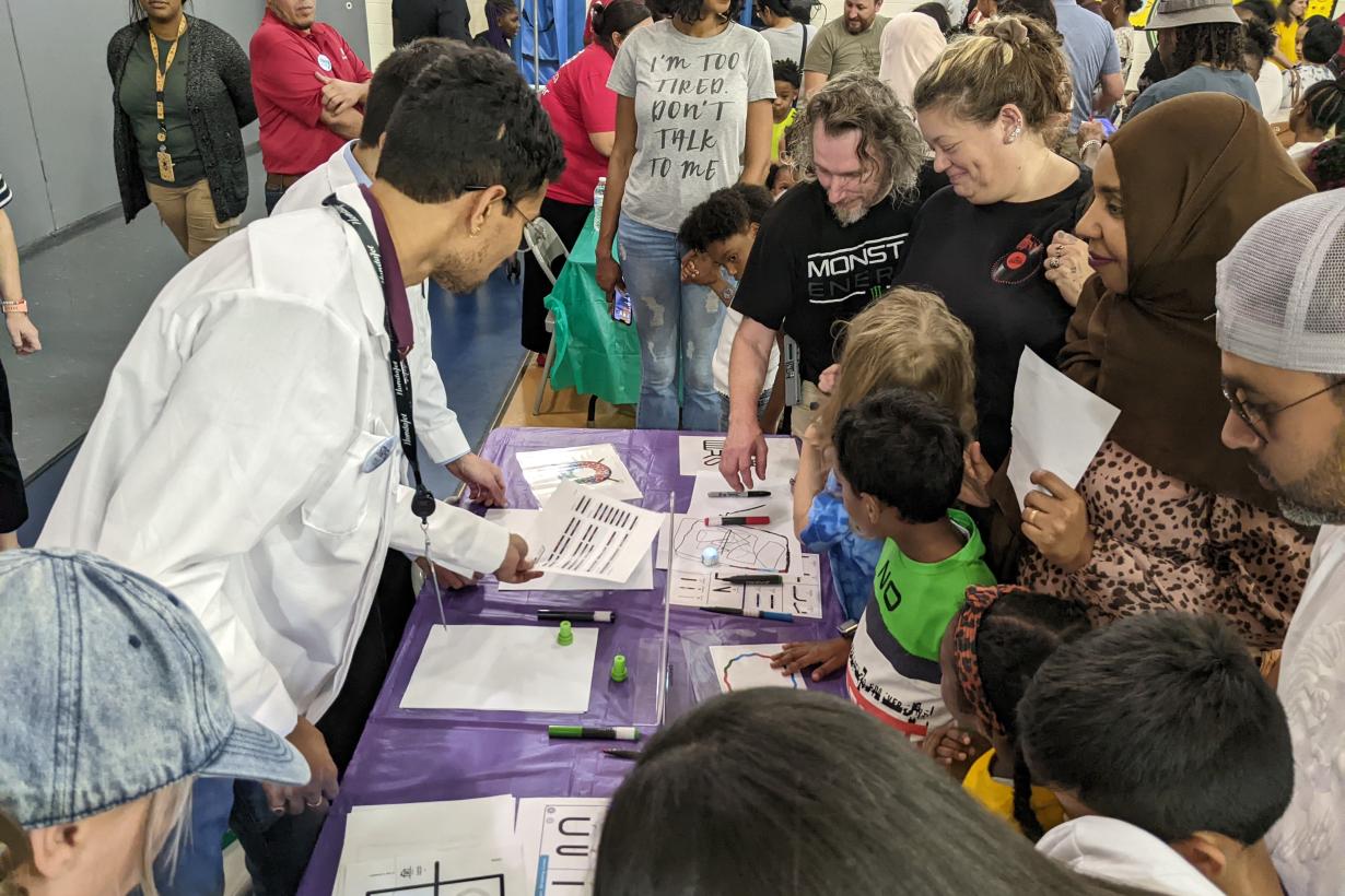 Greensboro Science Center family science night with families crowded around an hands-on activity table