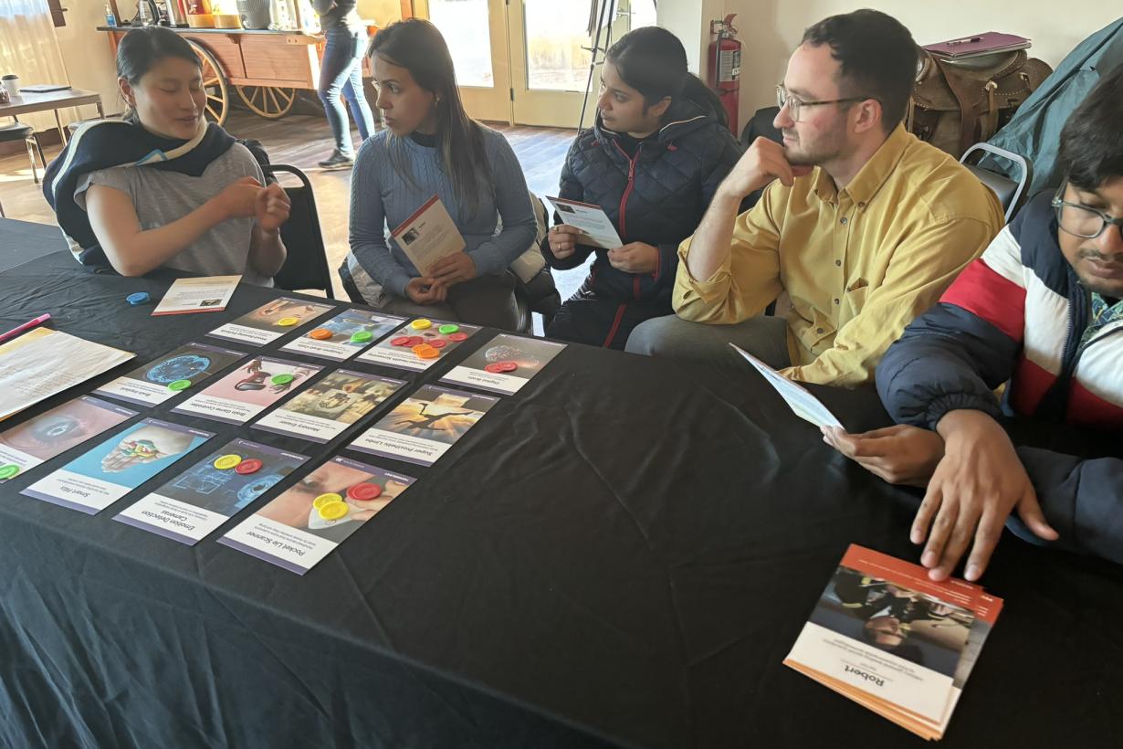 Adult Learners Sit Having Discussion While Engaging with the Neuro Futures Card Game