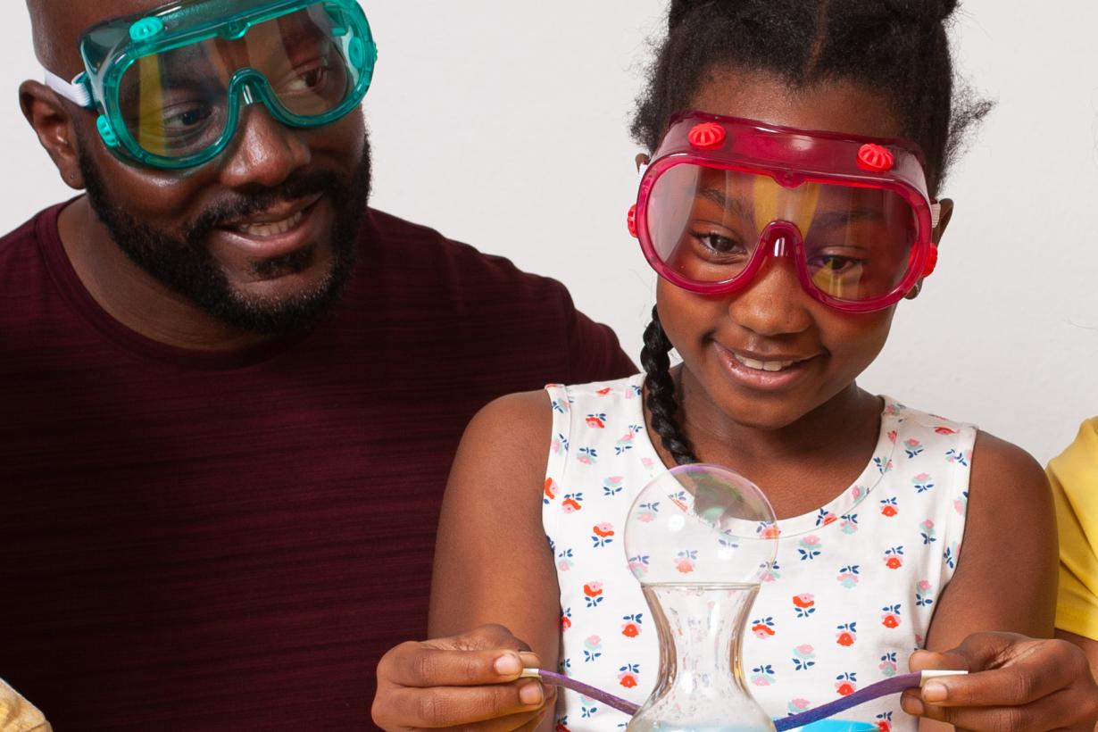 Father and daughter observing bubble in Sublimation Bubble activity in Explore Science: Let's Do Chemistry kit