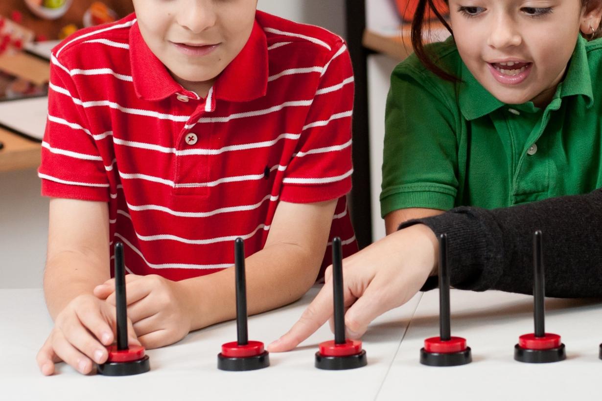 Children stacking magnets on posts in hands-on activity