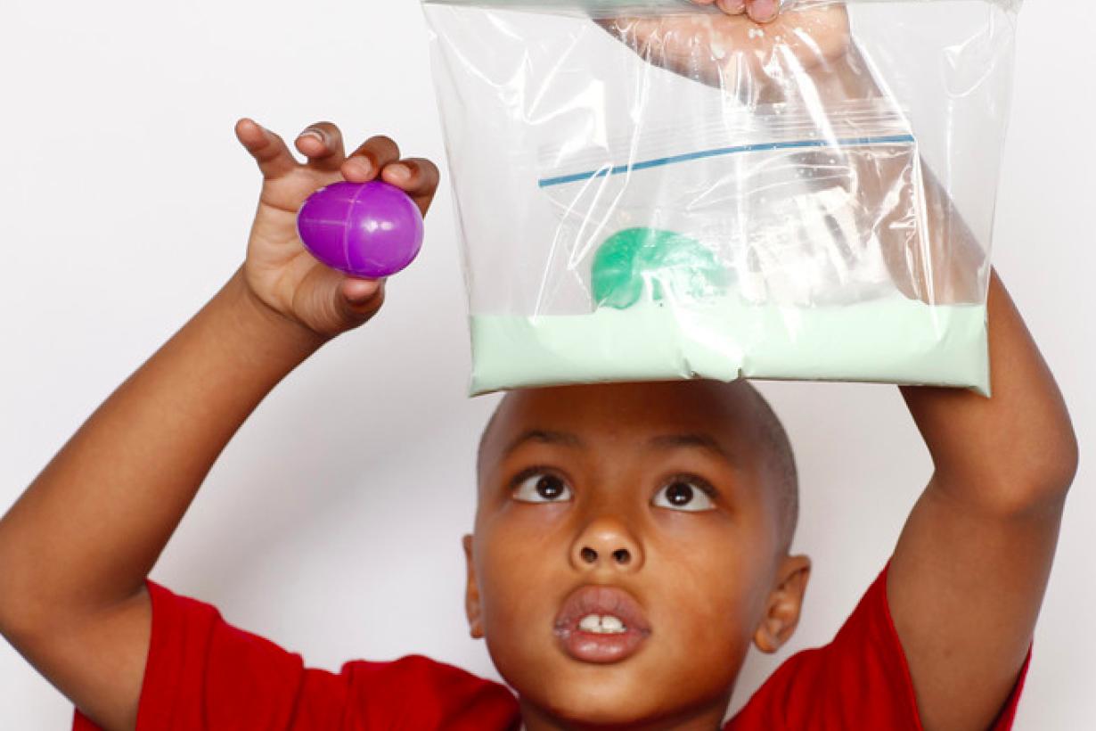 Boy holding a plastic bag of oobleck with a plastic Easter egg