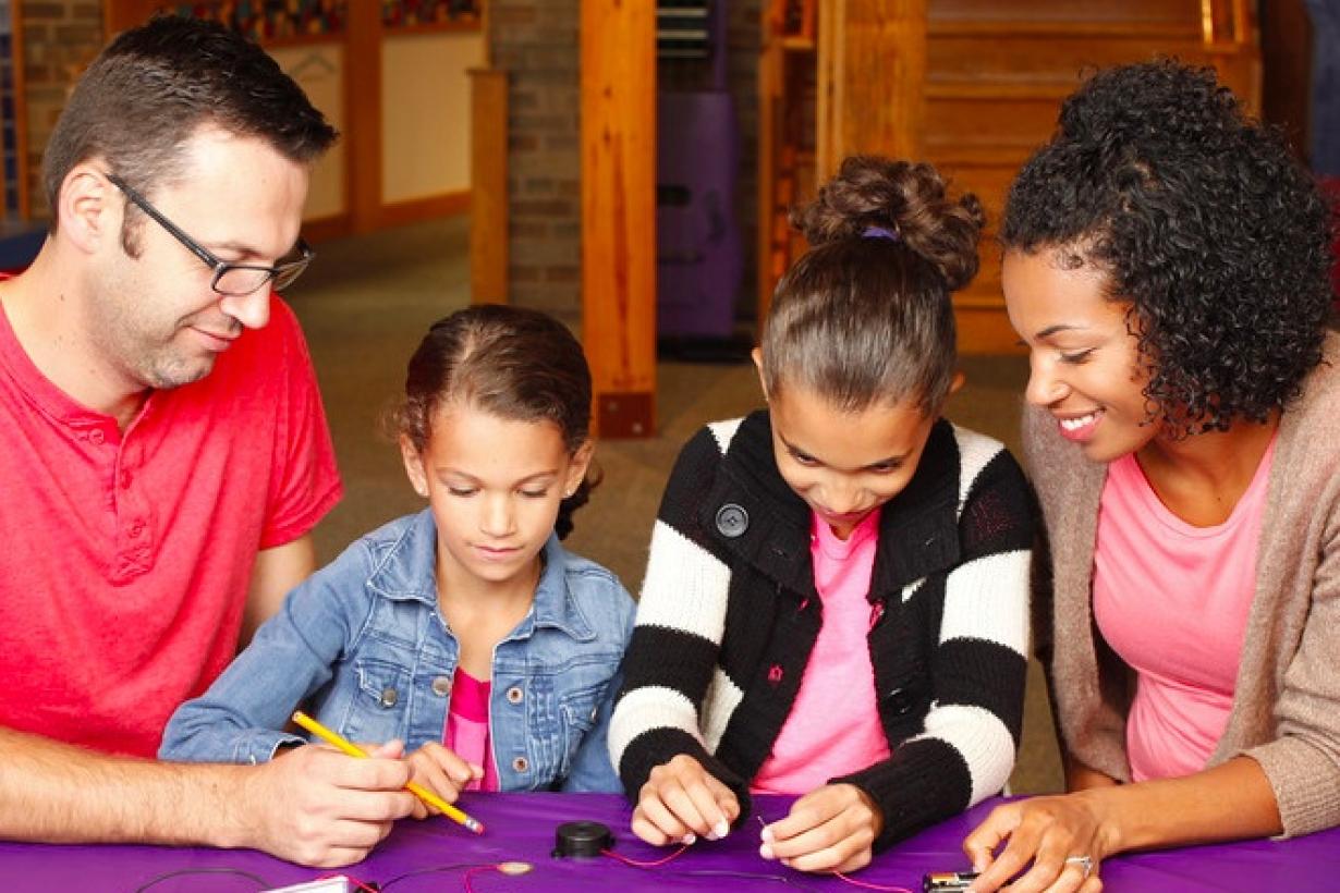 Family engaged in electric squeeze hadns-on activity