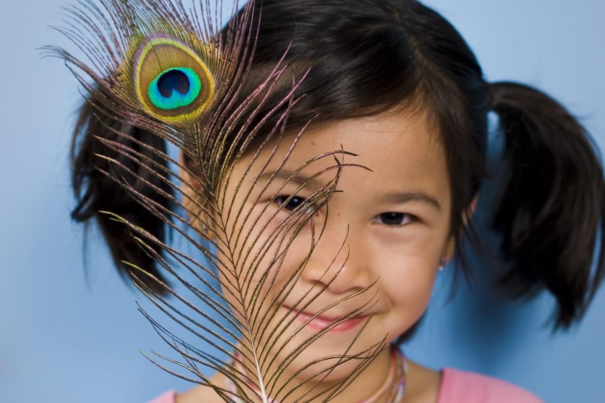 A girl with a peacock feather.