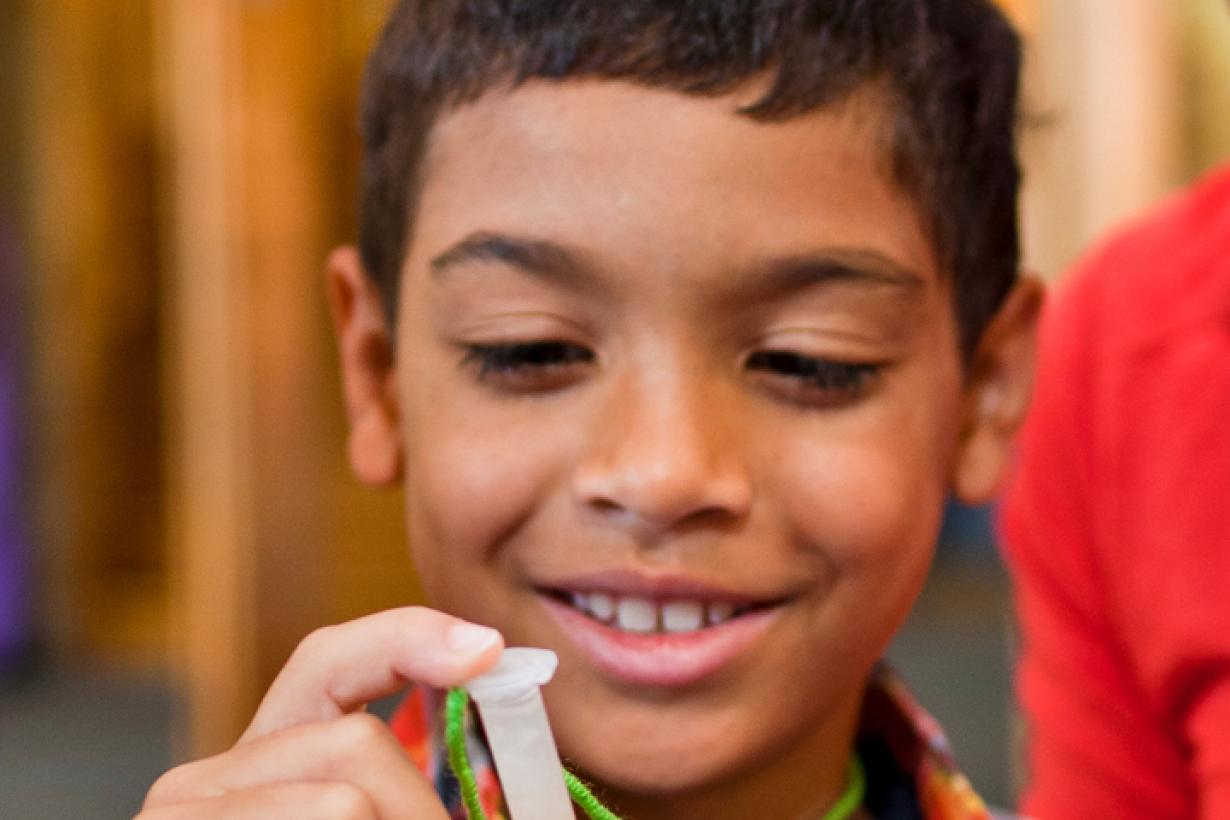 Boy holding small plastic test tube