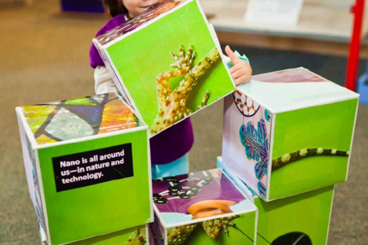 Young girl stacks large blocks with images on them