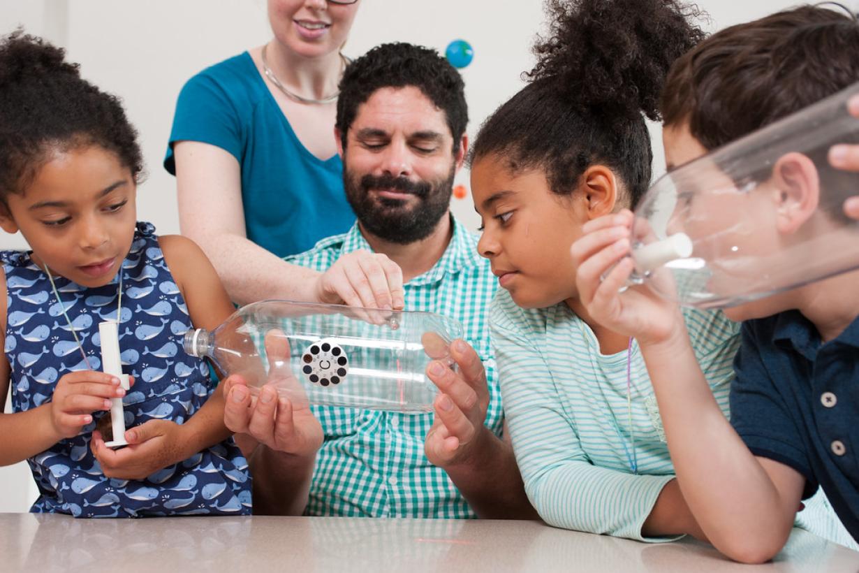 A group of learners observing a cloud that was made in a plastic bottle 