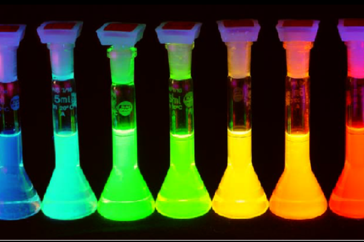 7 vials filled with quantum dots which are lit up and emit colored light