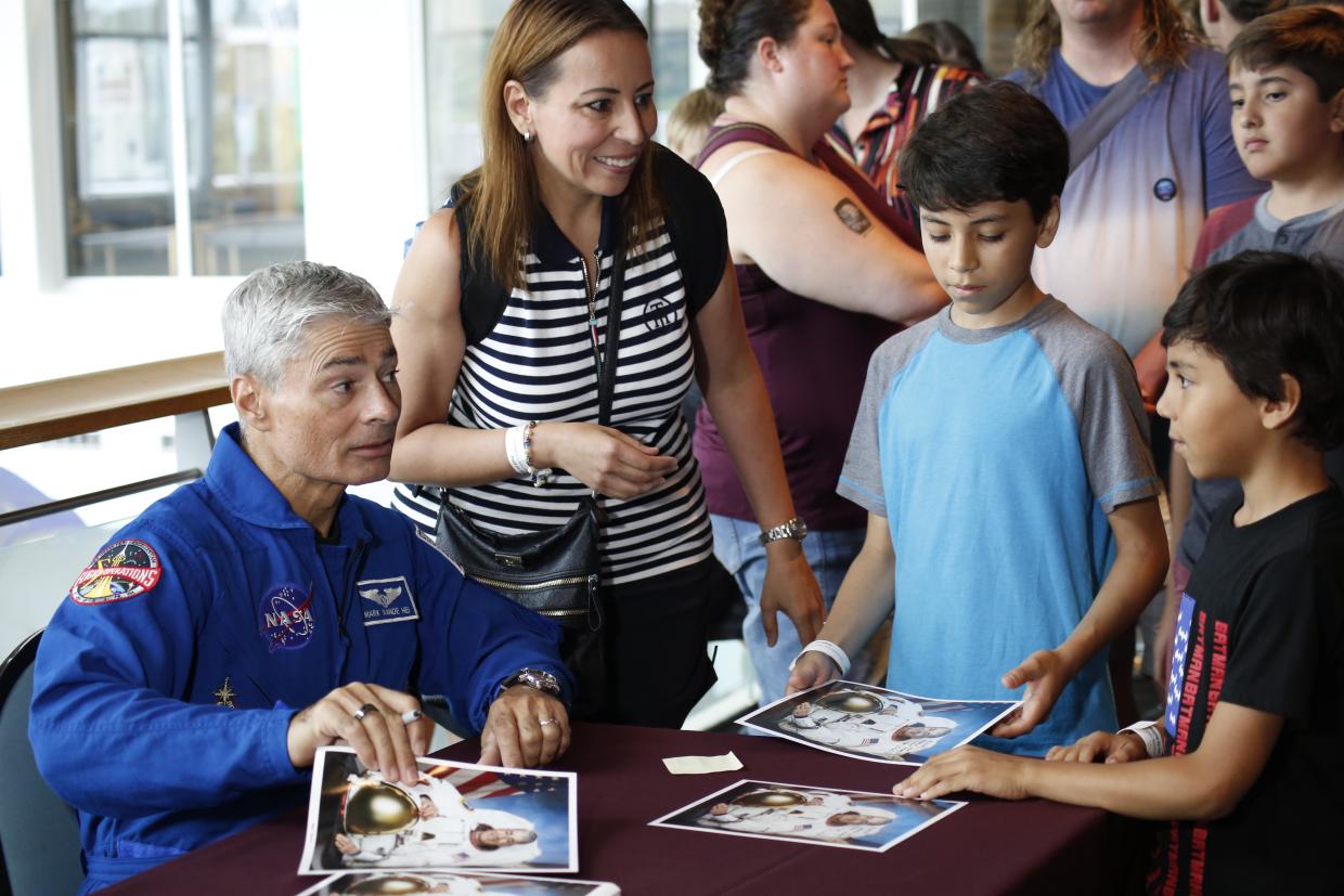NASA Astronaut Mark Vande Hei at Science Museum of Minnesota 2019 Moon Landing anniversary event signing autographs for young visitors
